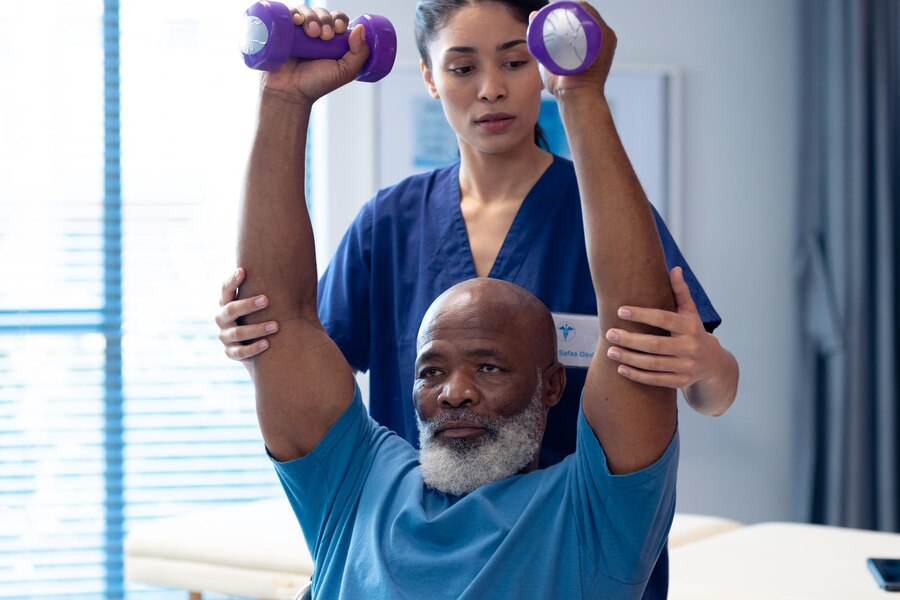 diverse-female-physiotherapist-helping-senior-male-patient-exercise-with-dumbbells-hospital-medical-healthcare-services_13339-337989